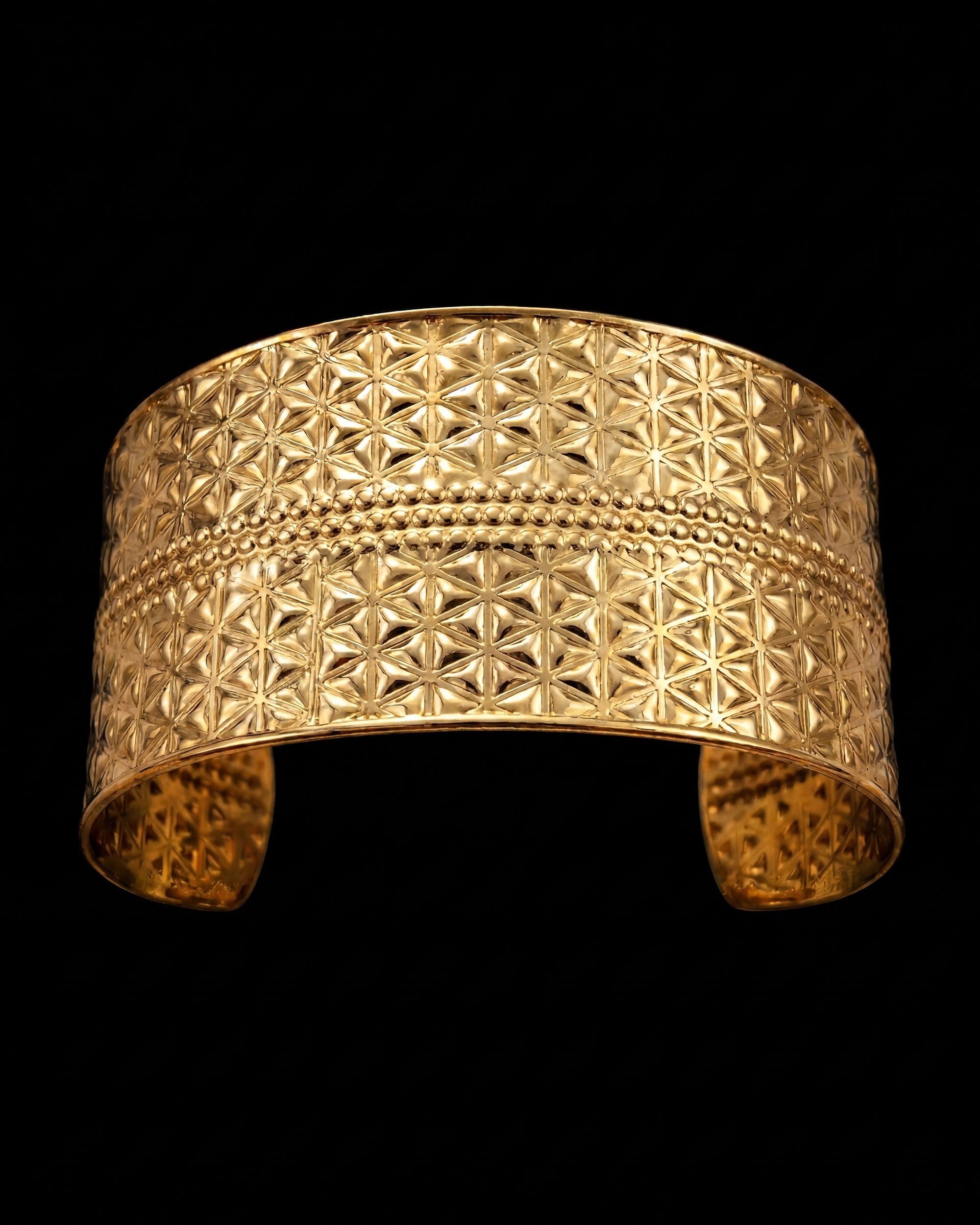Gold bracelet with geometric pattern on a black background