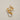Gold ring with a diamond on a textured beige background