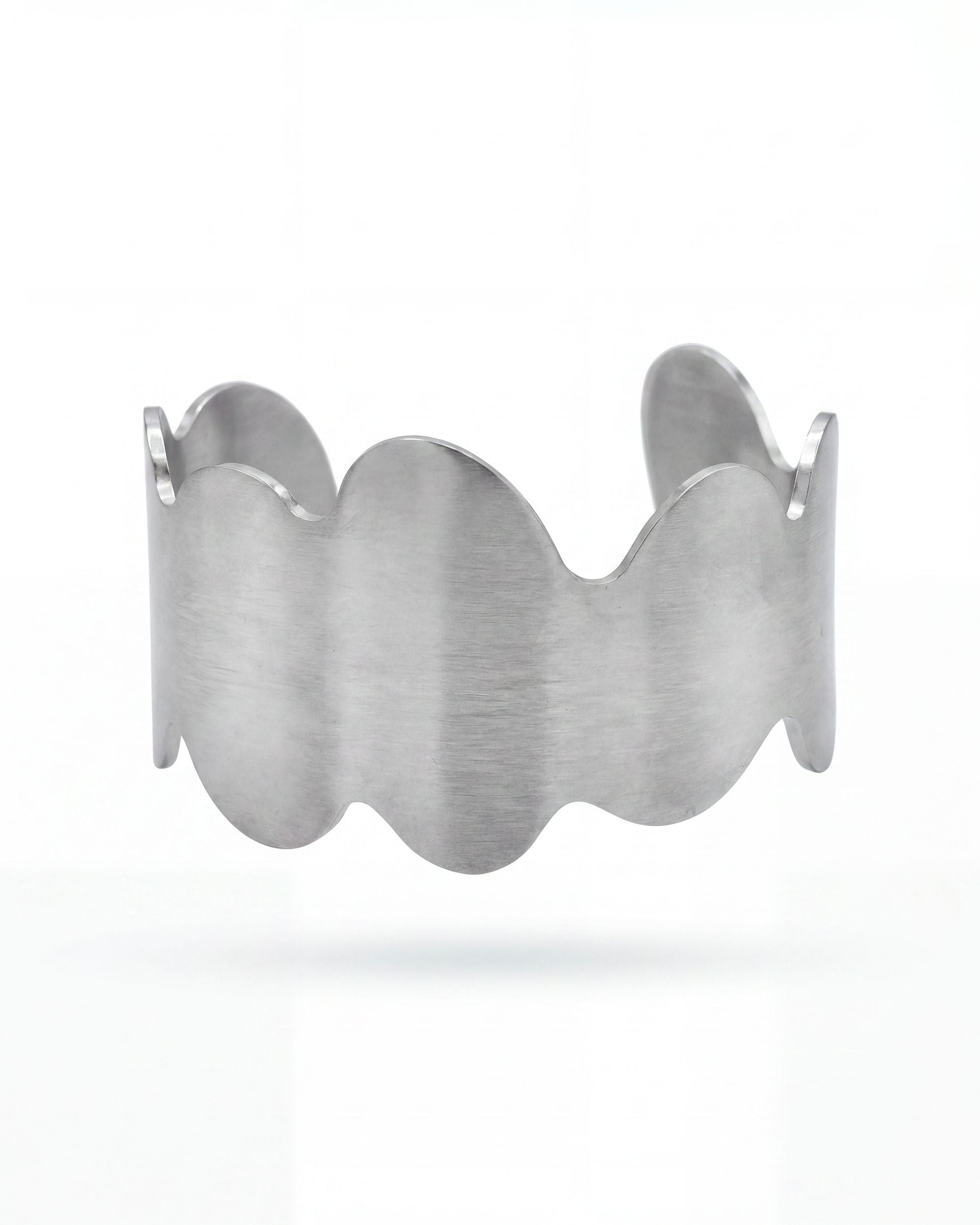 Silver bracelet with wavy design on a white background