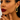Woman wearing gold hoop earrings with a neutral background